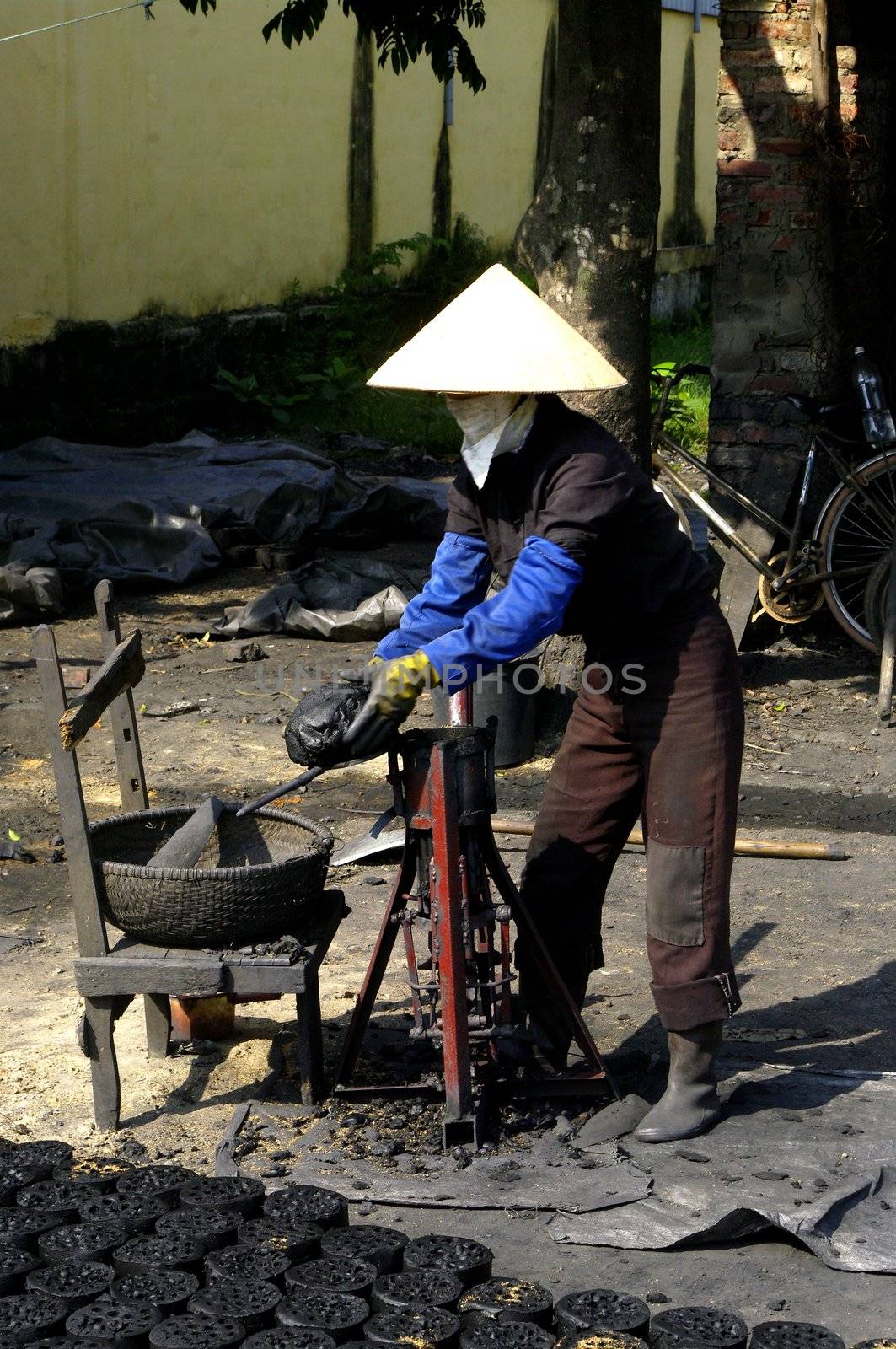 This woman using her machine manufactures cylinder of coal which are used even in town to cook. The gas bottle is too expensive for many homes.
The manufacture involves mixing coal dust with poor quality water into a paste. Then this paste is introduced into the upper part of the machine. Then closed the lid and then actuates the piston rises by below for compacting the dough and make holes in the pavement of coal. It is dried in the sun