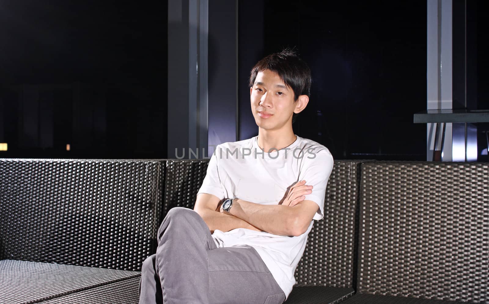 Man sit on a bench while relaxing at a pub. 