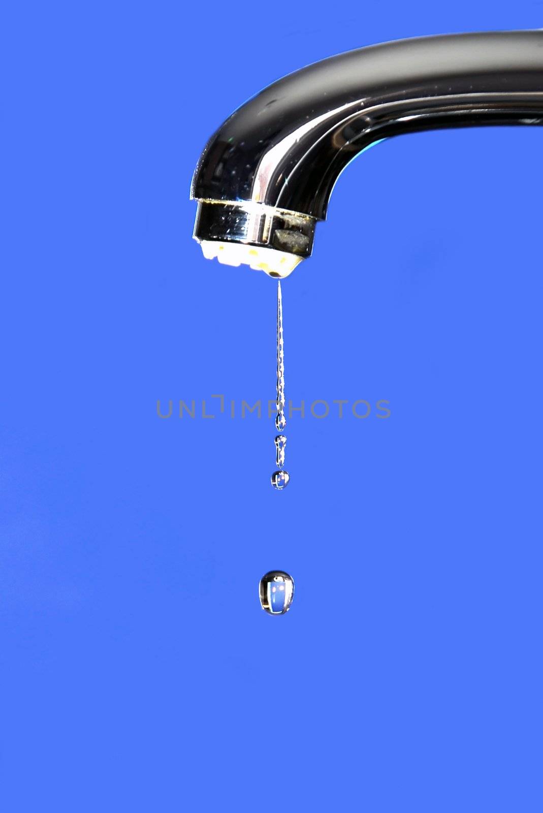 silver metallic water tap with drops over blue