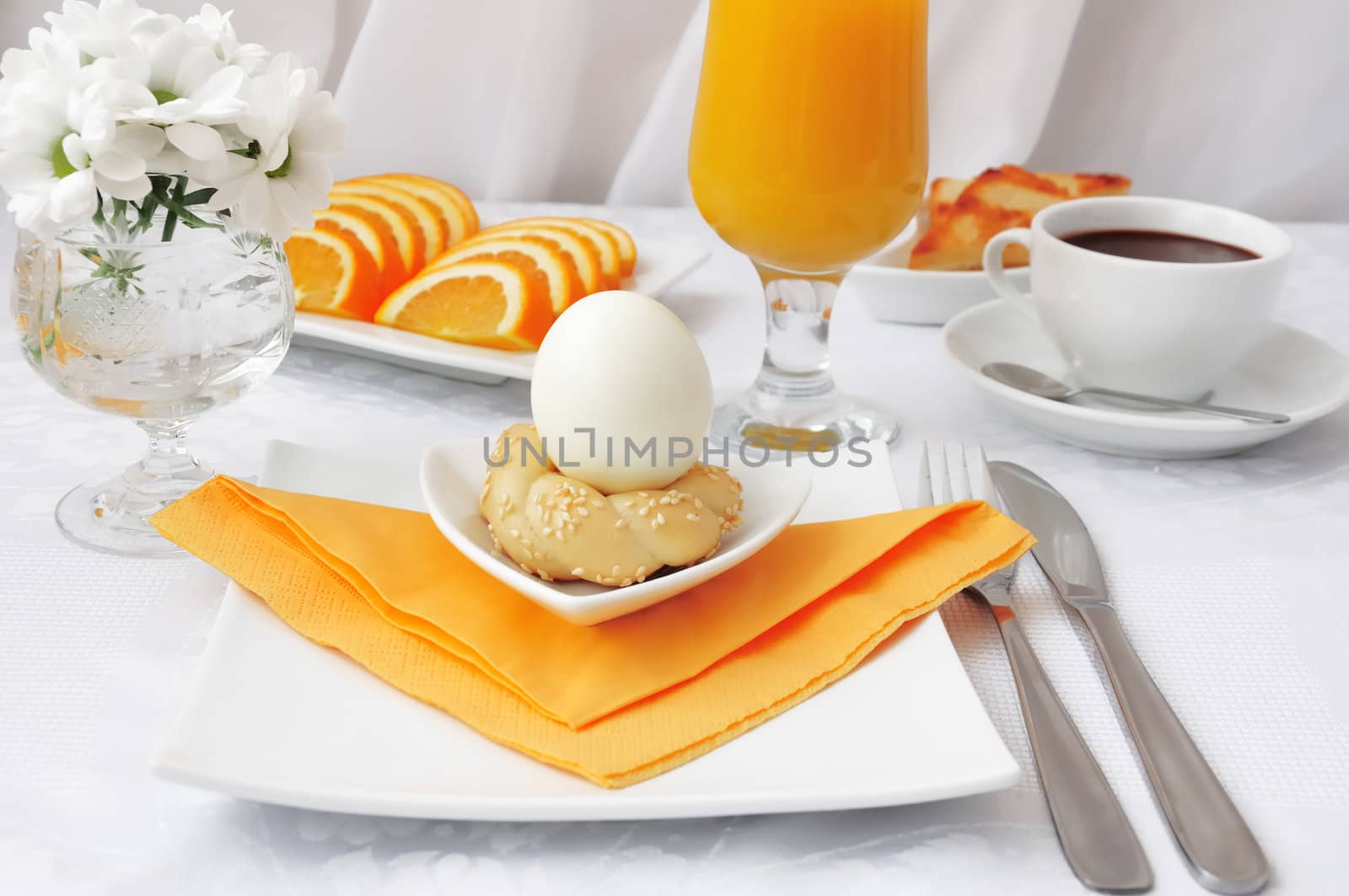 Breakfast with an egg on the pedestal of the dough with hot chocolate and orange juice