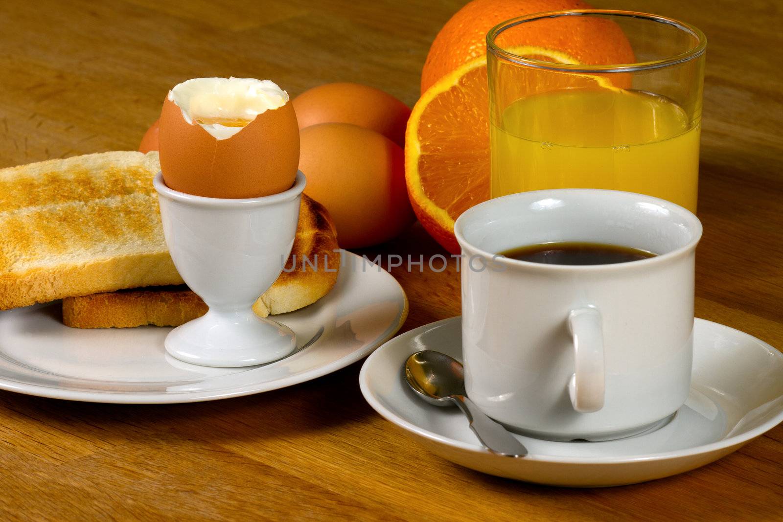 Breakfast: Boiled egg, toast, coffee and fresh orange juice. On Wooden table