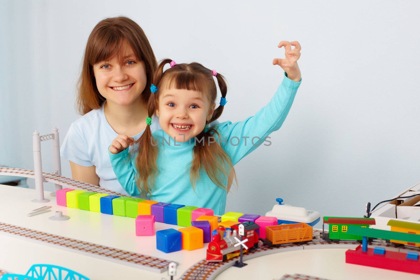 Mother and daughter having fun playing with toys