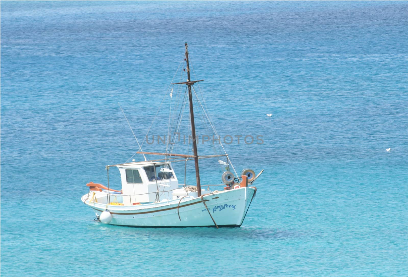 a boat over crystral clear blue water from greece island