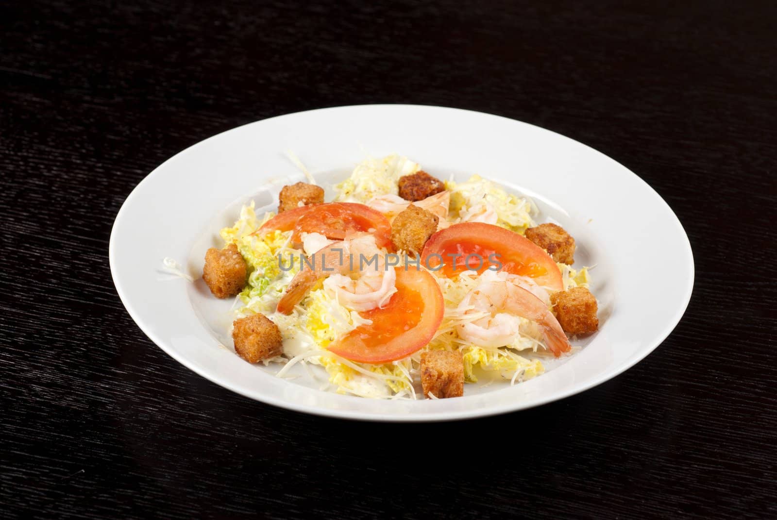 Salad of tiger shrimps, lettuce, chinese cabbage, tomato, garlic rusk, parmesan cheese and sauce