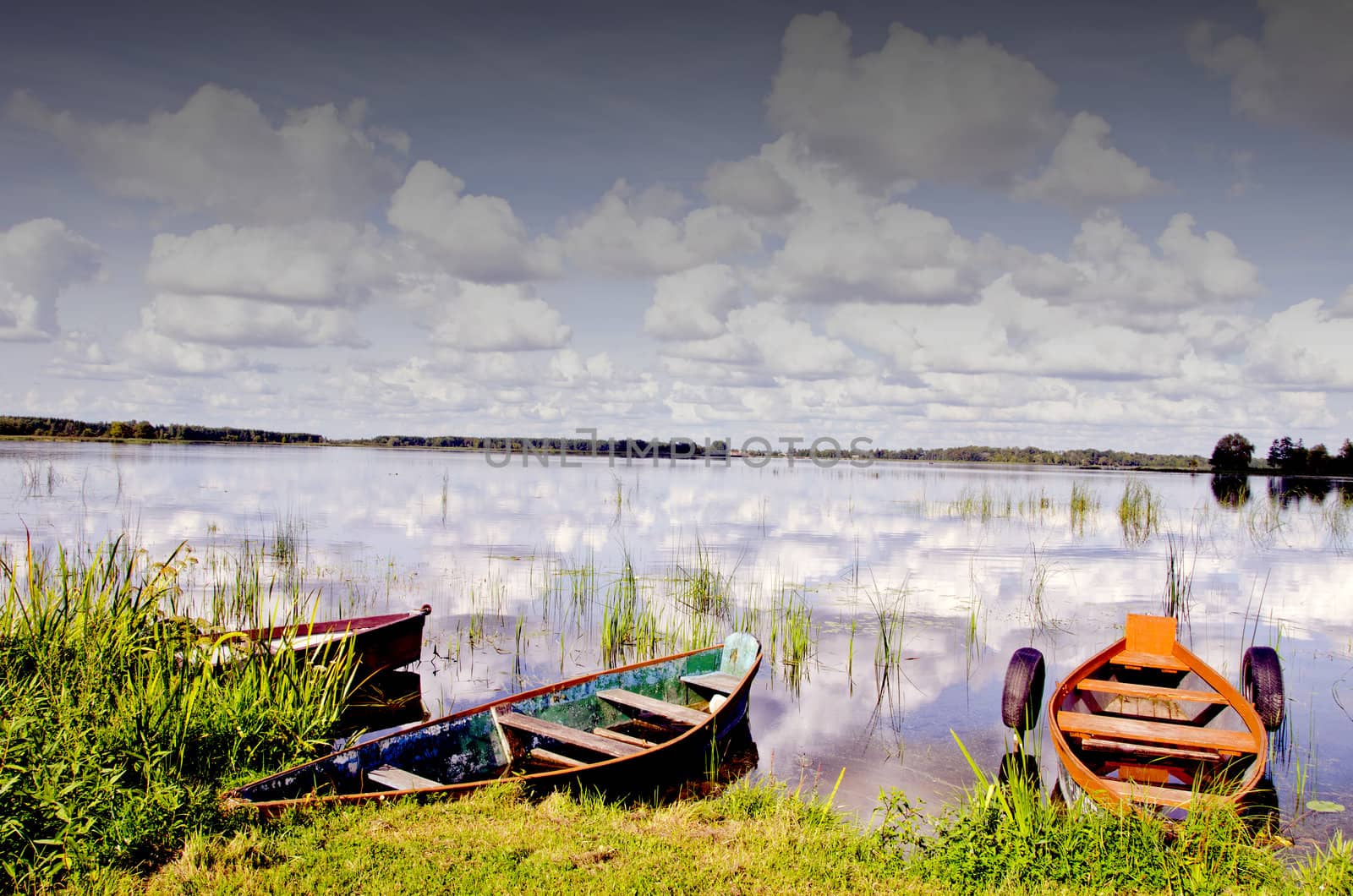 Colorful boats resting on the lake coast with nice view of lake.