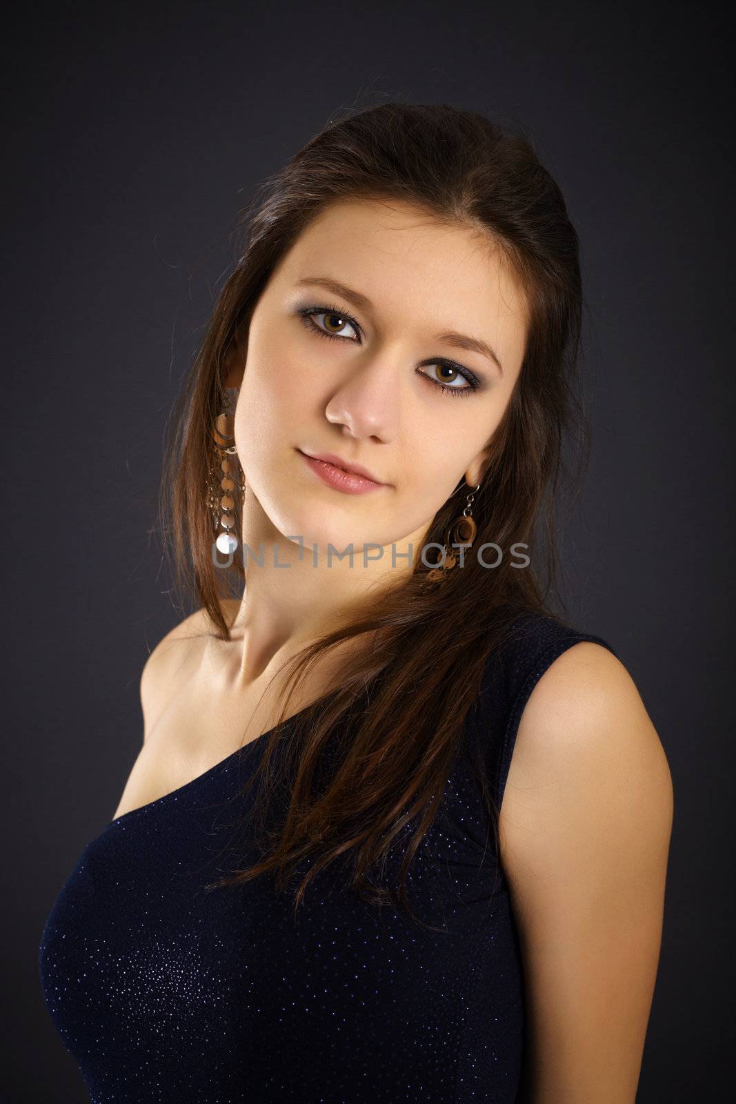 Portrait of a beautiful young woman in evening dress on black background