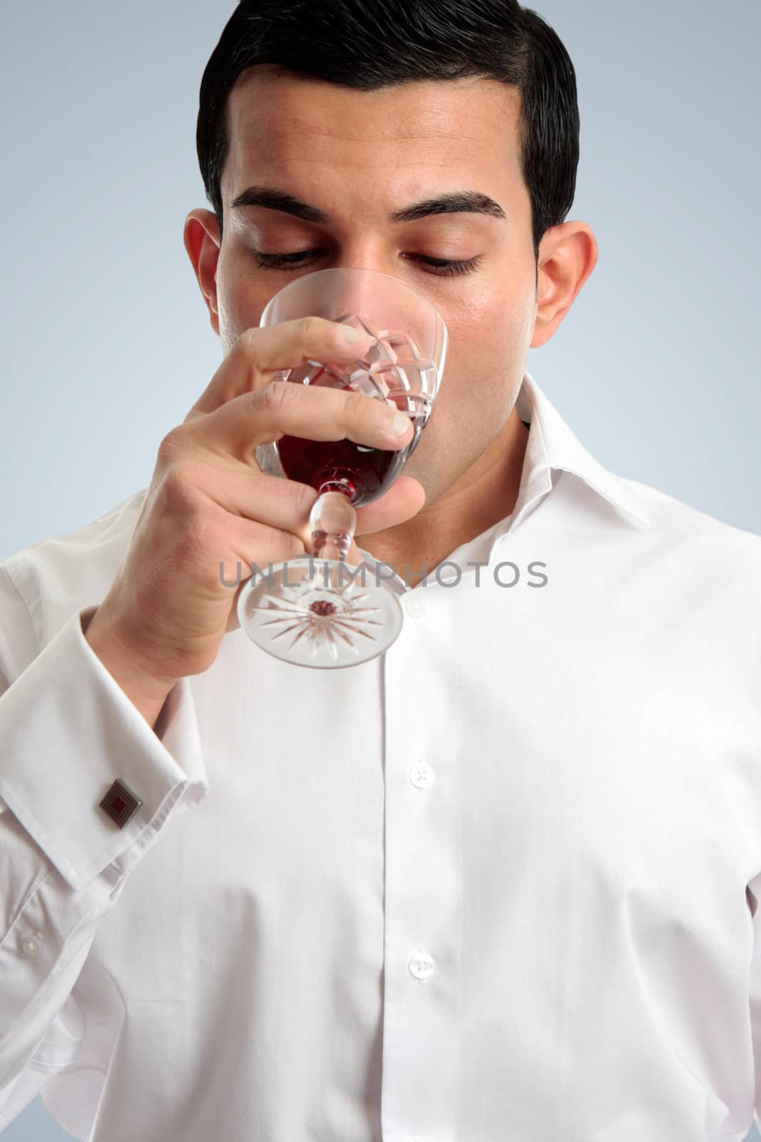 Closeup of a professional man drinking or tasting wine in a glass.