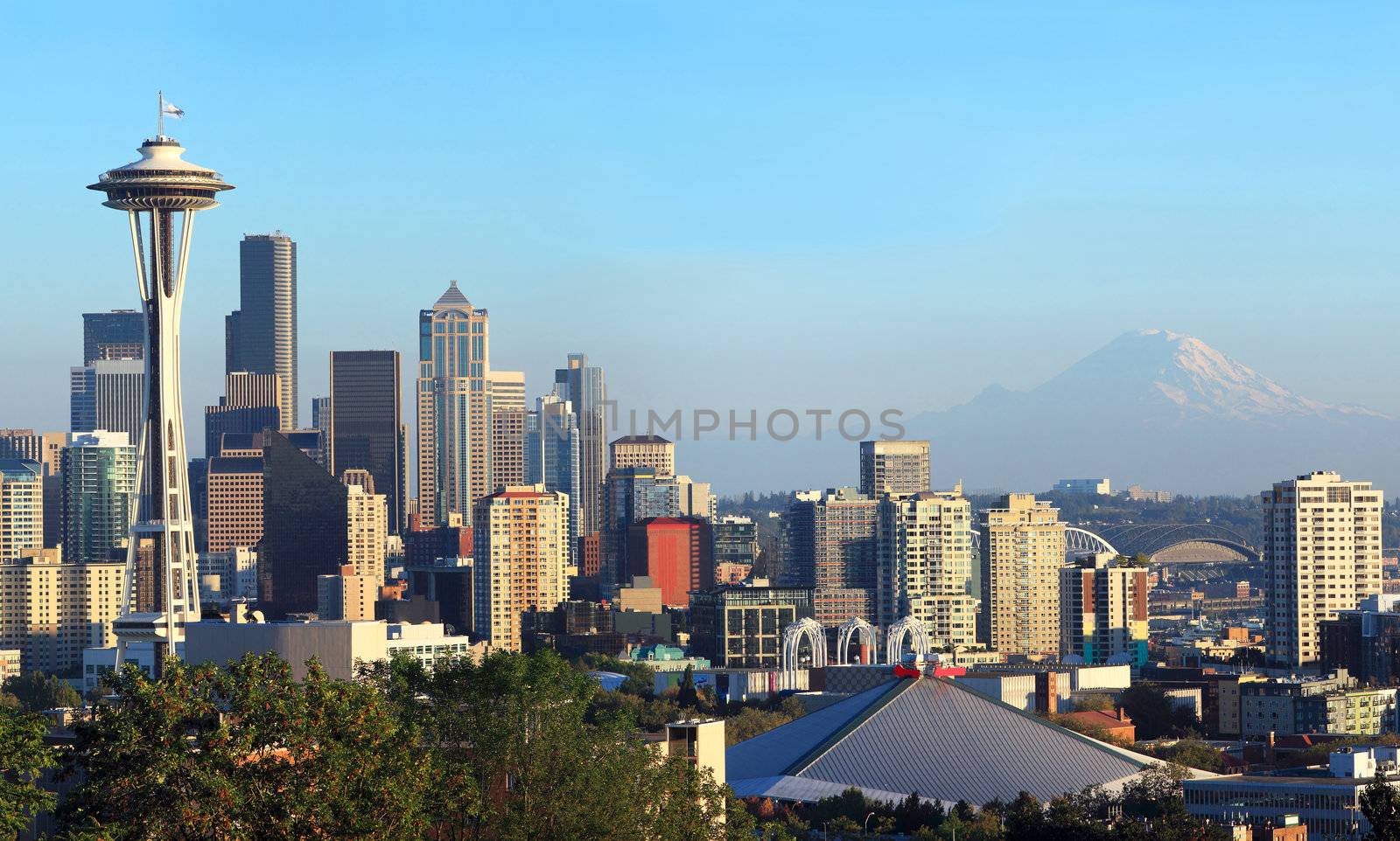 A panoramic view of the city of Seattle skyline and Mt. Rainier at sunset.