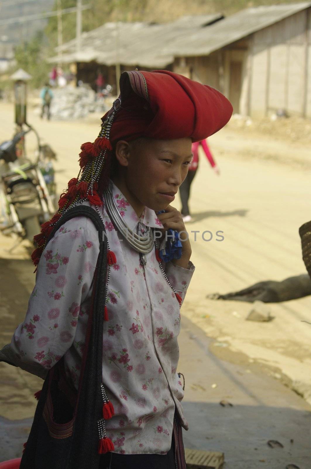 Woman of the ethnic (minority) Hmong red pompoms. This beautiful woman is the traditional clothing of his tribe and the headdress of married women. The standard of beauty for women in Asia is to have white skin.