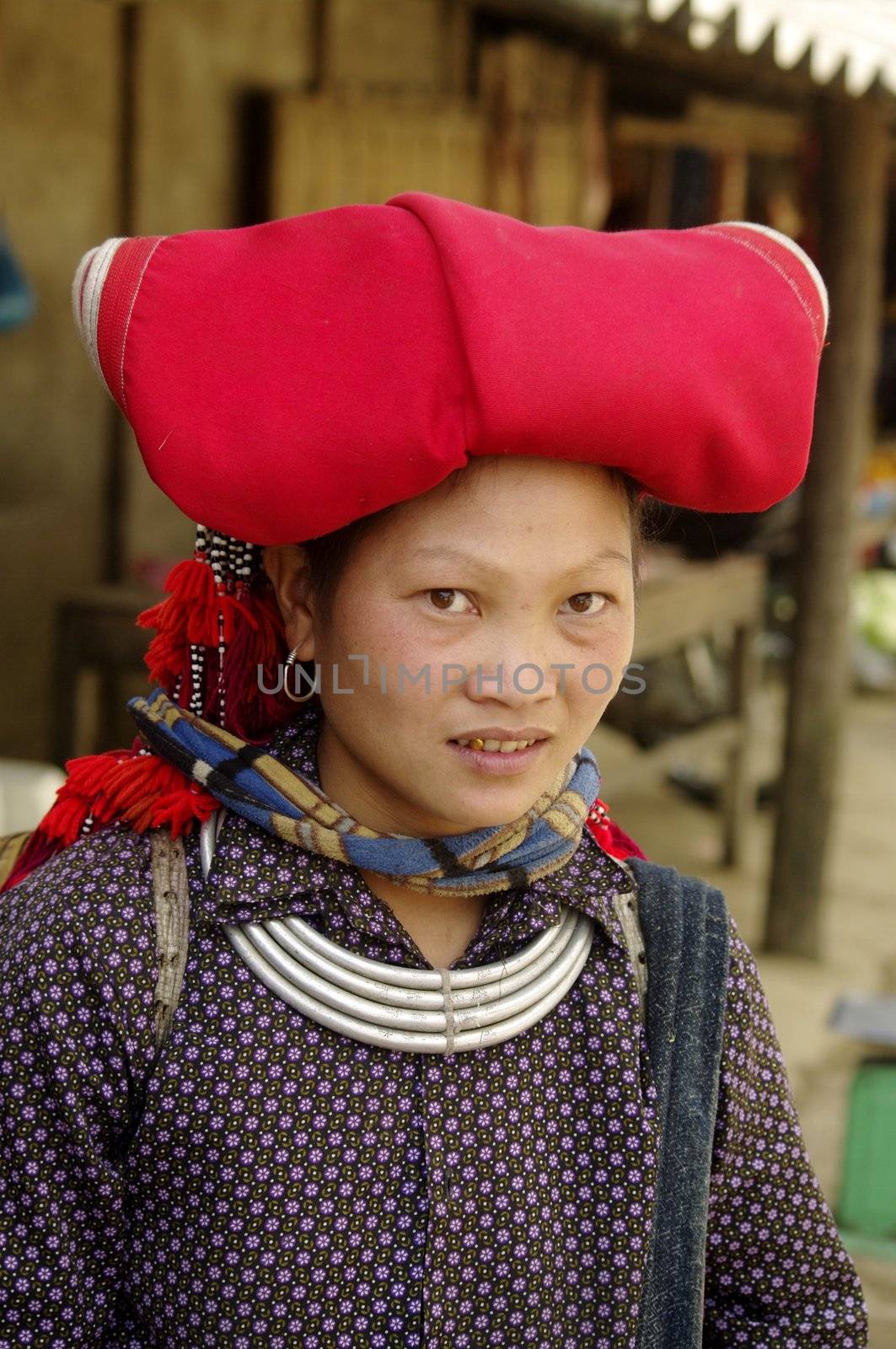 Woman of the ethnic (minority)red Dao pompoms. This beautiful woman is the traditional clothing of his tribe and the headdress of married women. A basket in the back he used to transport vegetables to the house and contains the essential umbrella, which also serves to protect against the sun. The standard of beauty for women in Asia is to have white skin
