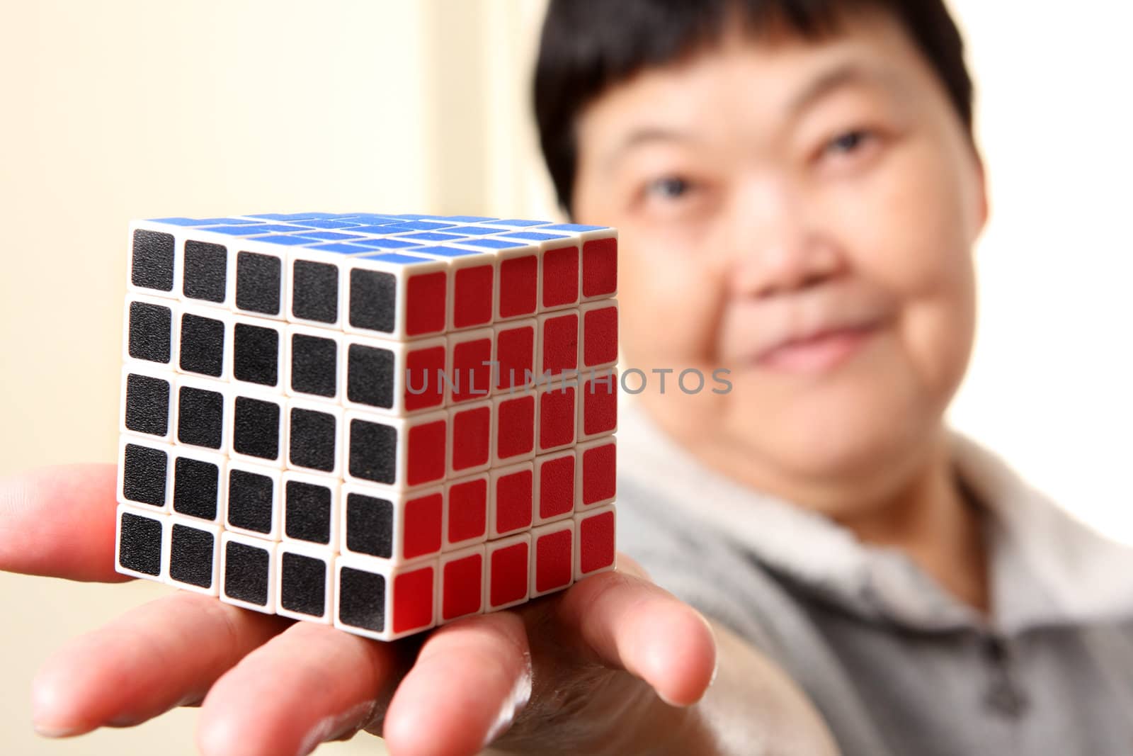 senior chinese woman show a complete  rubik cube