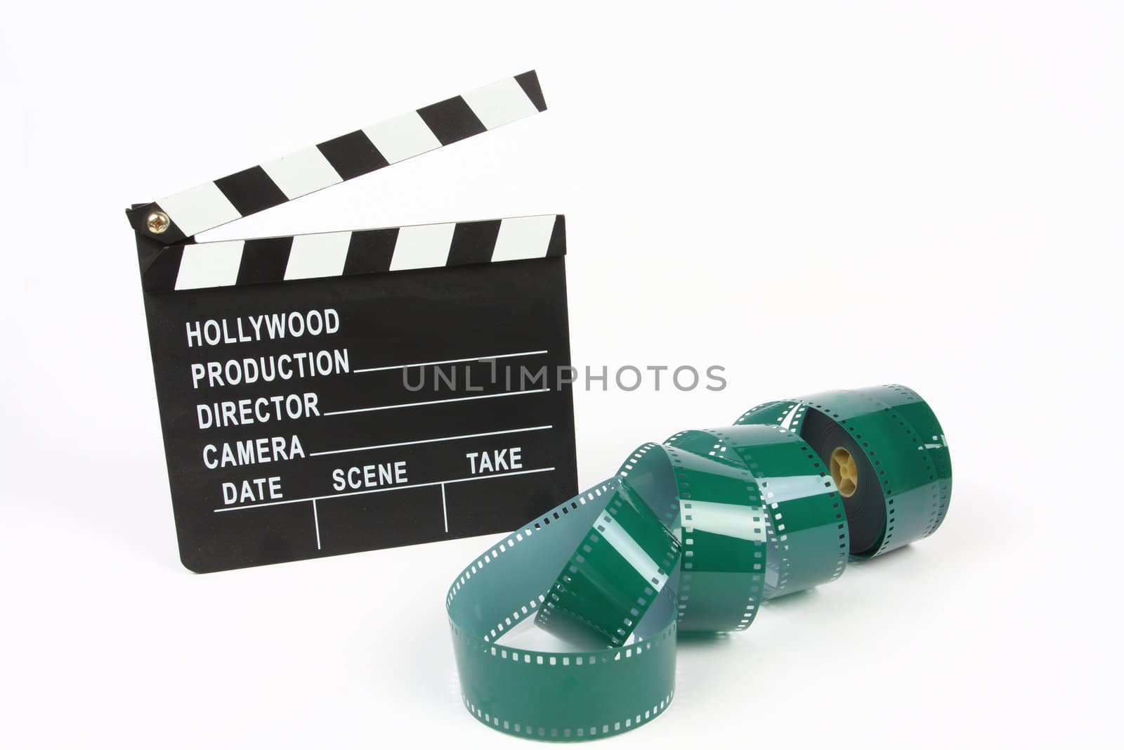 Movie clapper board and film roll over white 