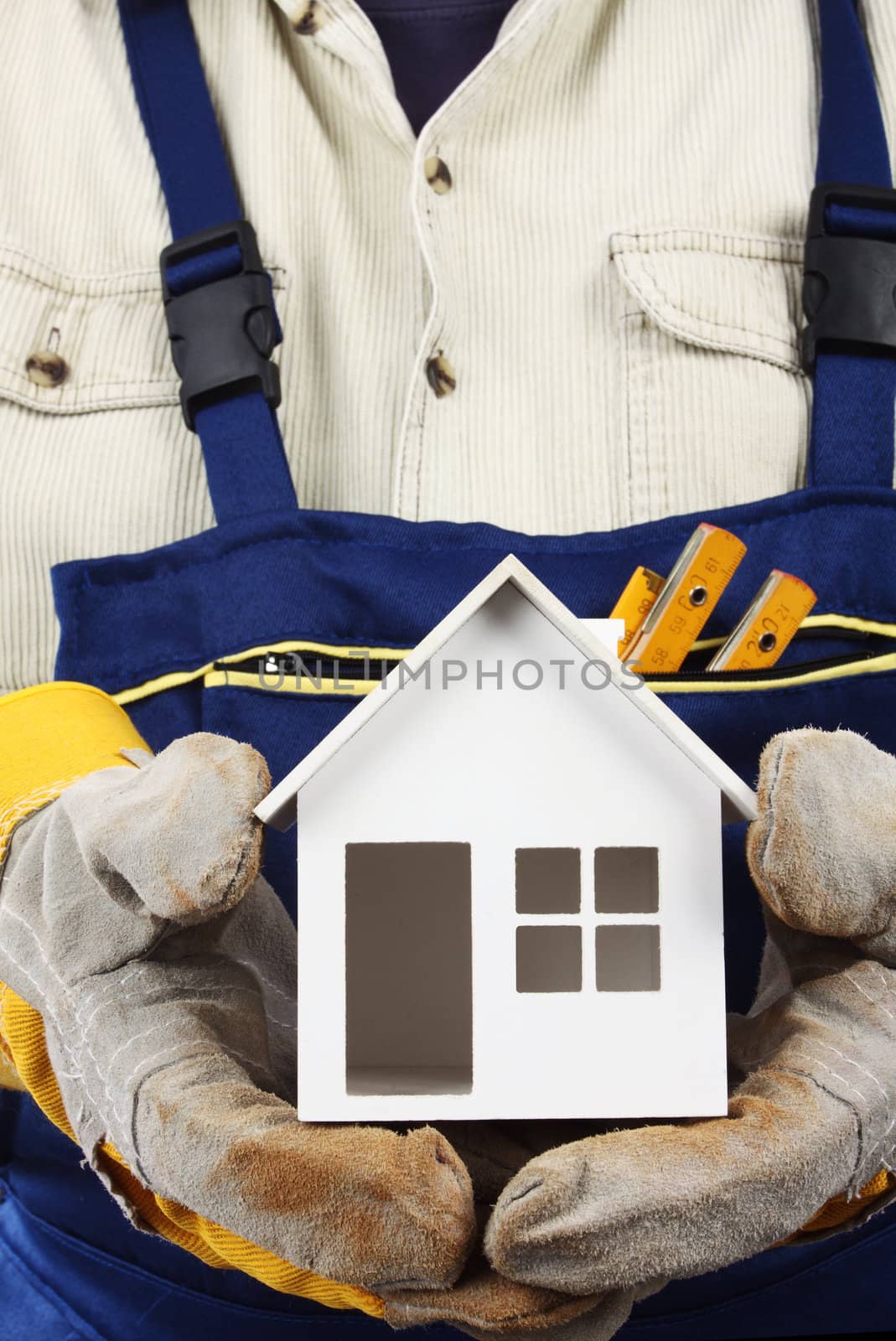 Worker holding house model in hand. Real property or insurance concept 