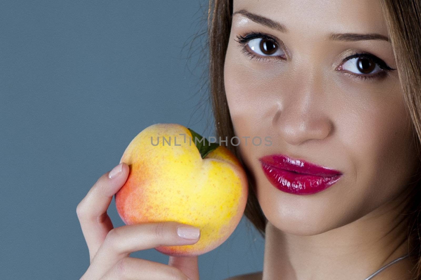 Sexual model with a peach in a hand