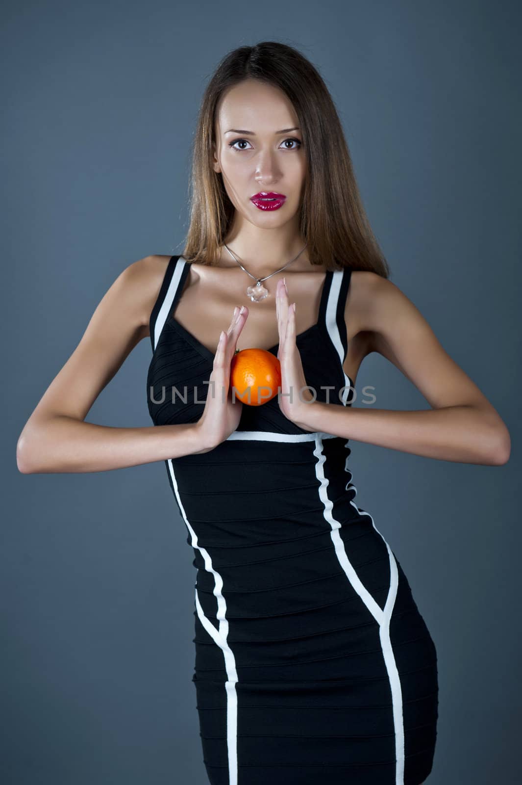 Young model with an orange in hands by Aleksandr