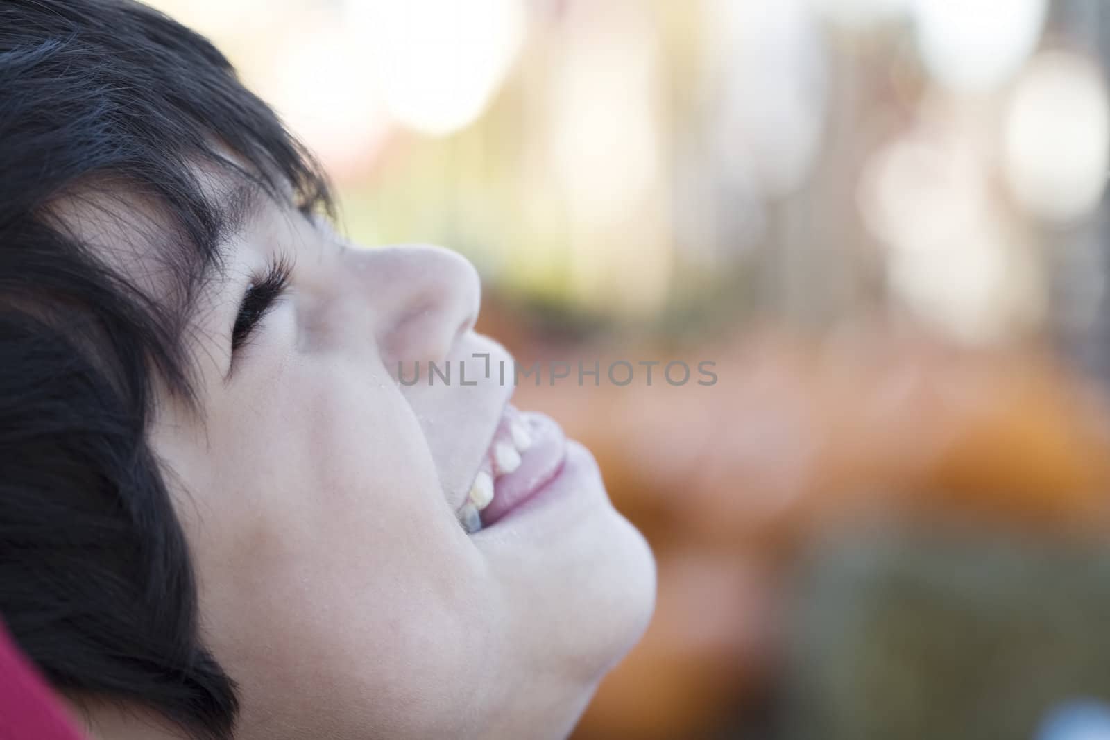 Happy little boy smiling up, profile