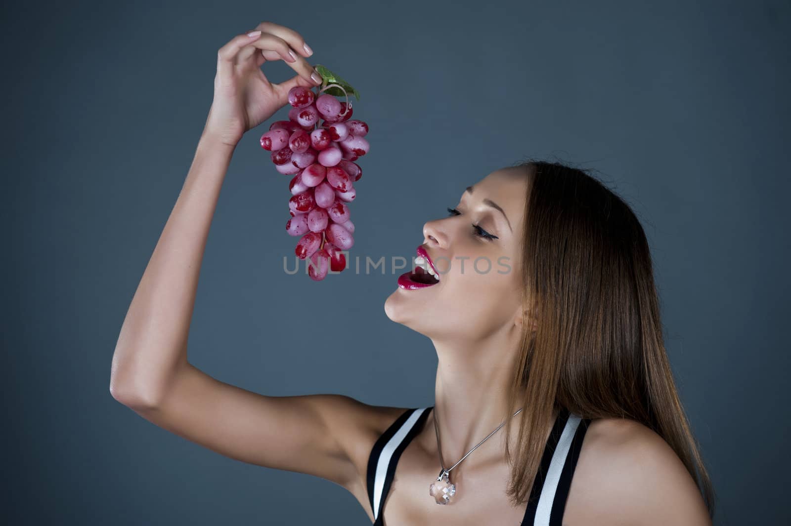 The beautiful girl with grapes in a hand