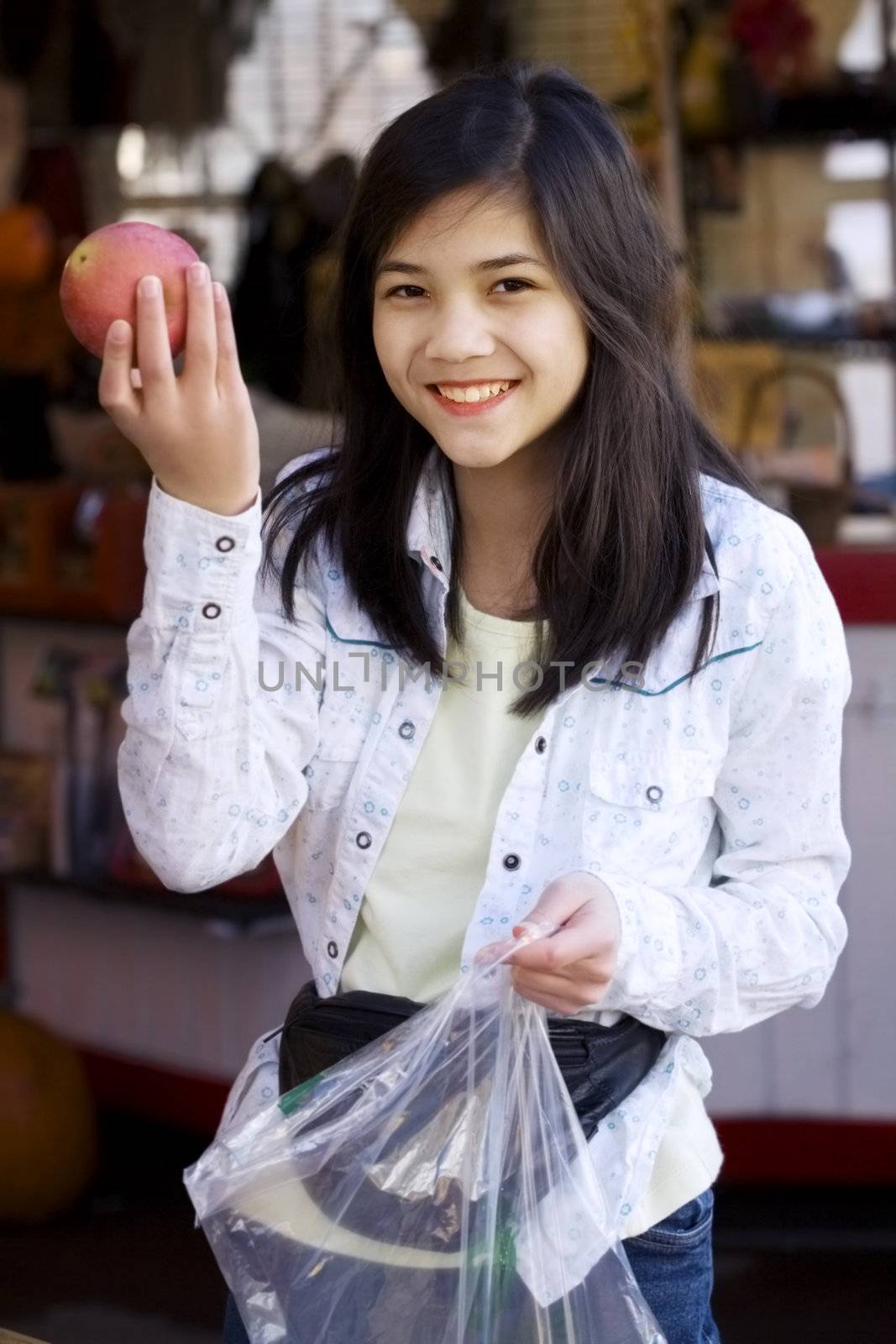 Young girl picking out apples at a farmer's market