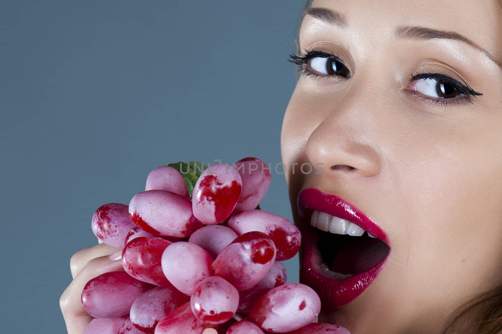 Portrait of model with grapes in a hand