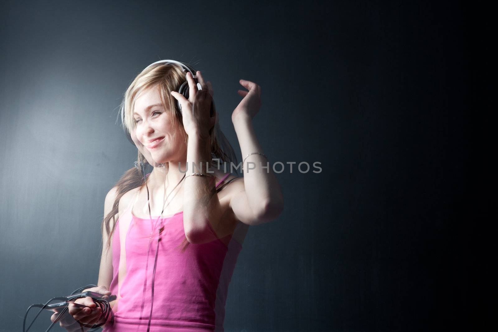 Music please! - Portrait of a pretty young woman/teenager listening to music on her hi-end headphones, enjoying the groove (multiple esposure shot)