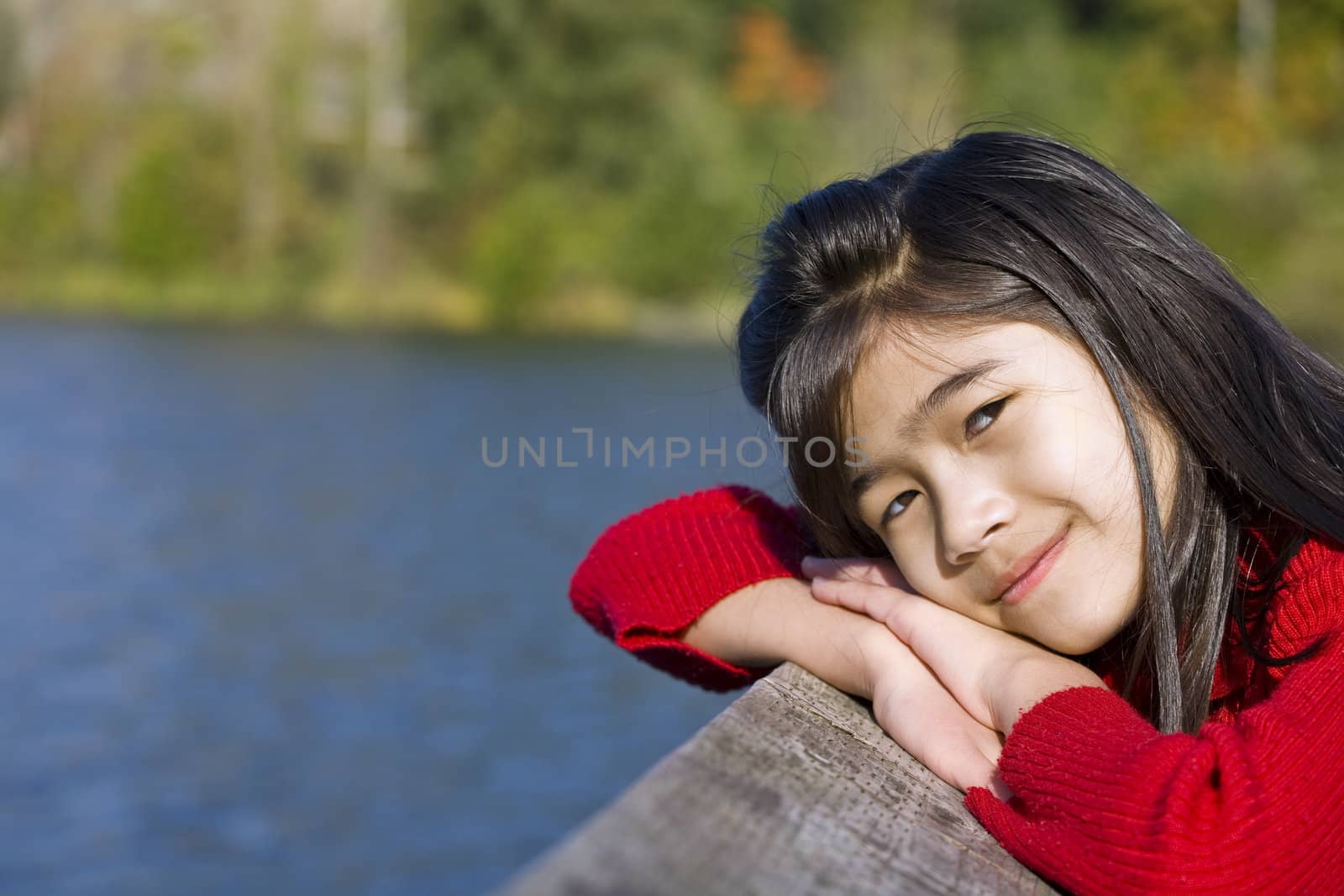 Little asian girl relaxing by lake