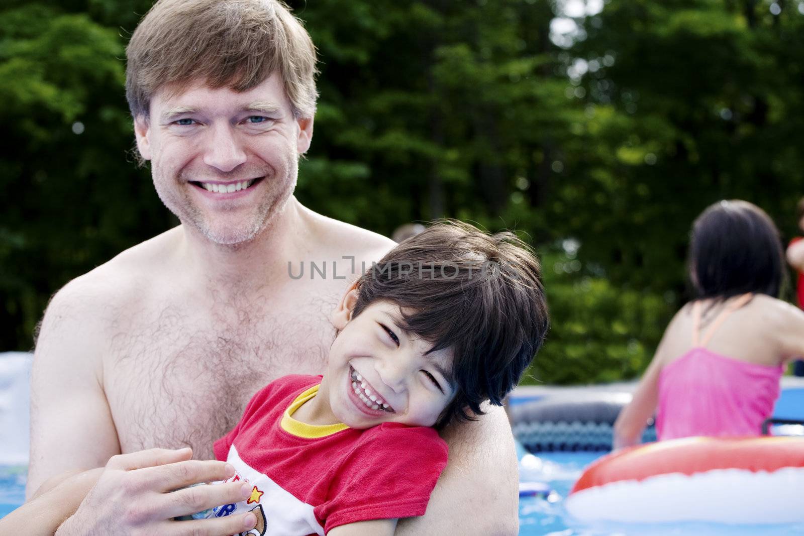 Father holding disabled son in pool by jarenwicklund