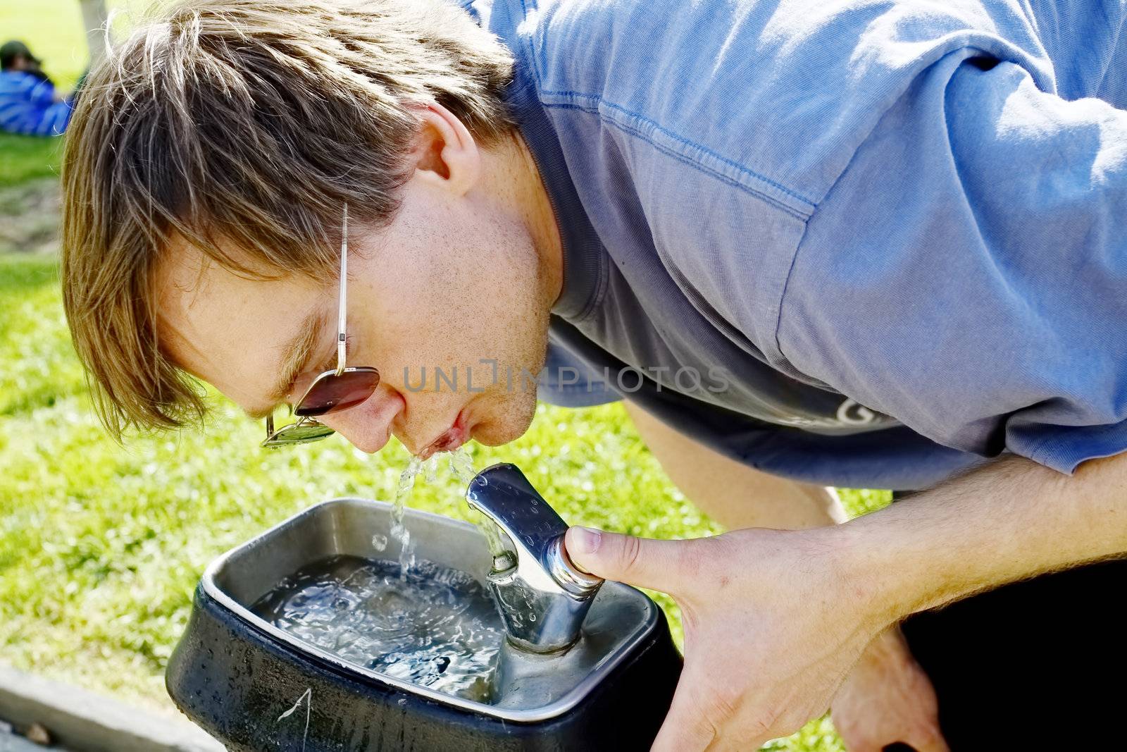 Man drinking water from fountain