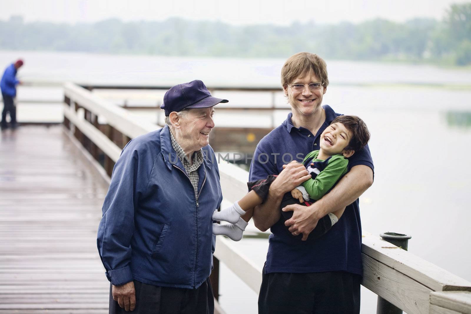Three generations interacting together on the dock on misty morning