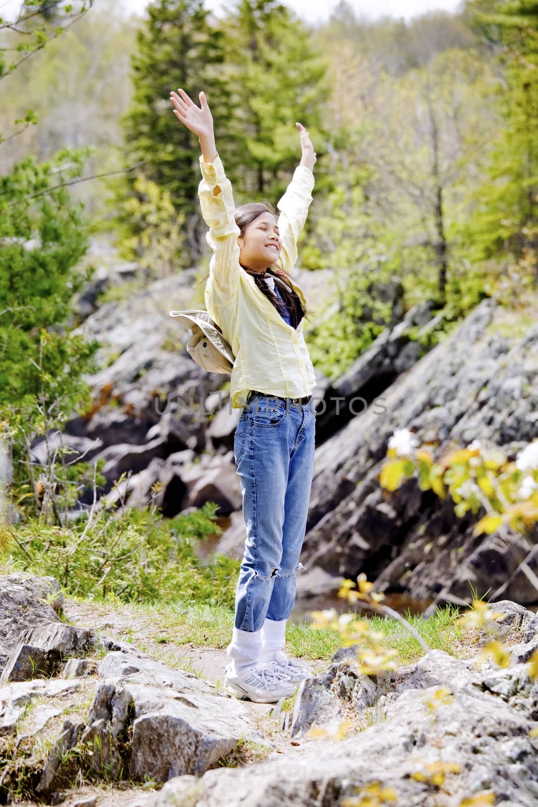 Girl raising hands in praise outdoors