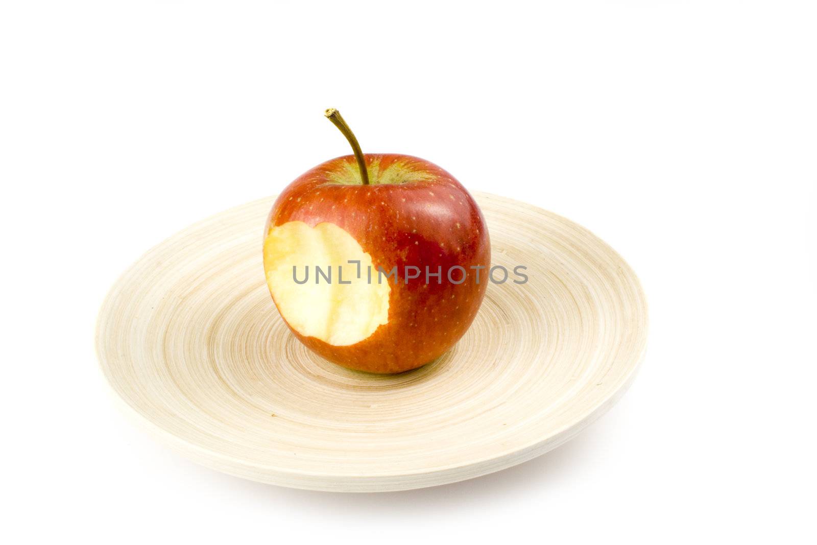 Nibbled stripped apples on plate on white background