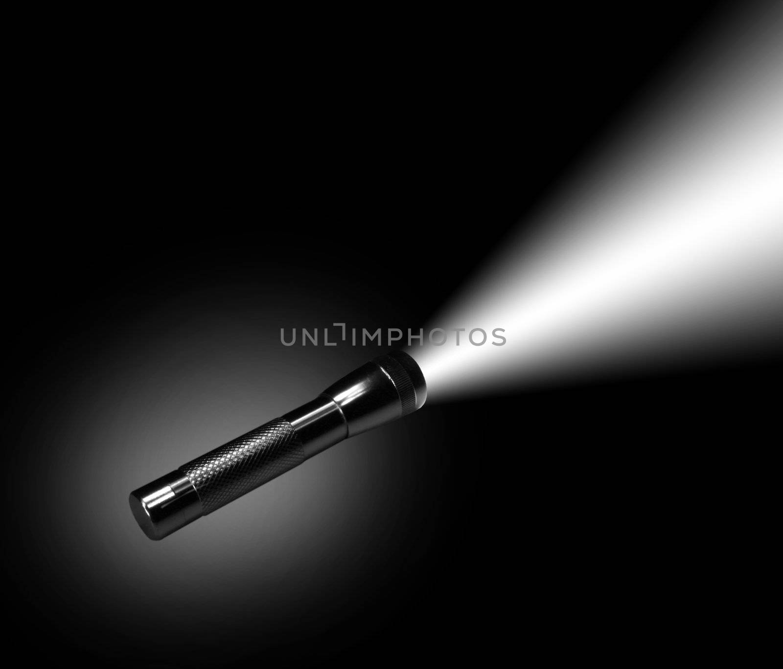 Aluminum flashlight in night on black background