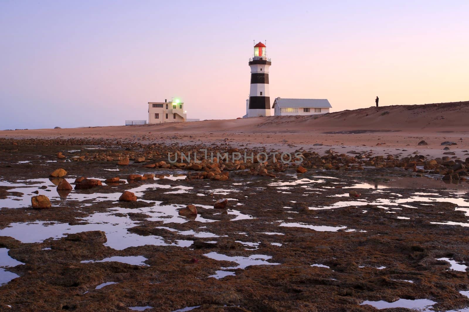 Lighthouse and sunset at the coast at low tide