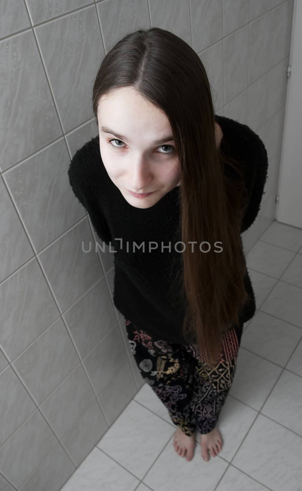 Girl standing in the bathroom, looking upwards