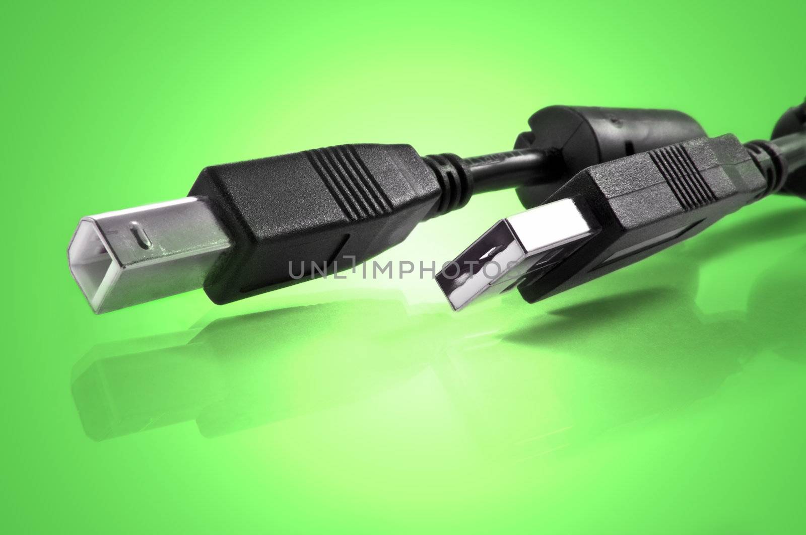Close up of two usb cables against green light effect background