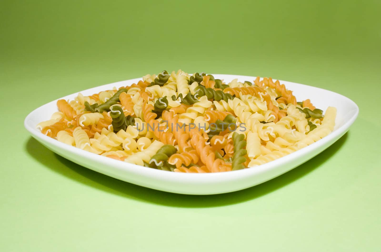 Pasta on green background (on white plate)