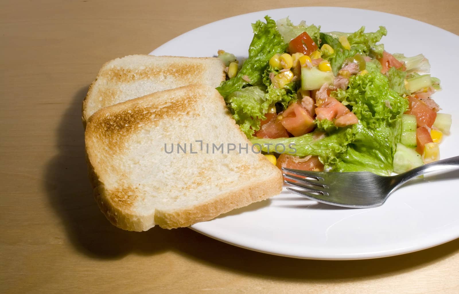 Vegetable salad with toast and fork