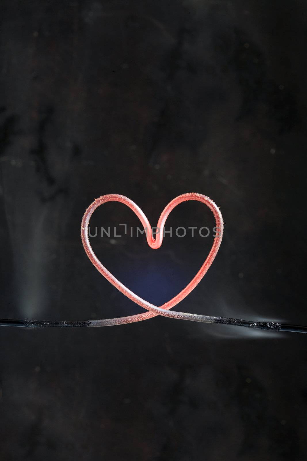 Hot heart made from metal wire isolated on dark background