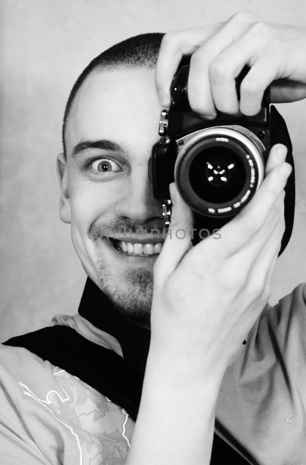 young man with a photographic camera staring from behind the camera
