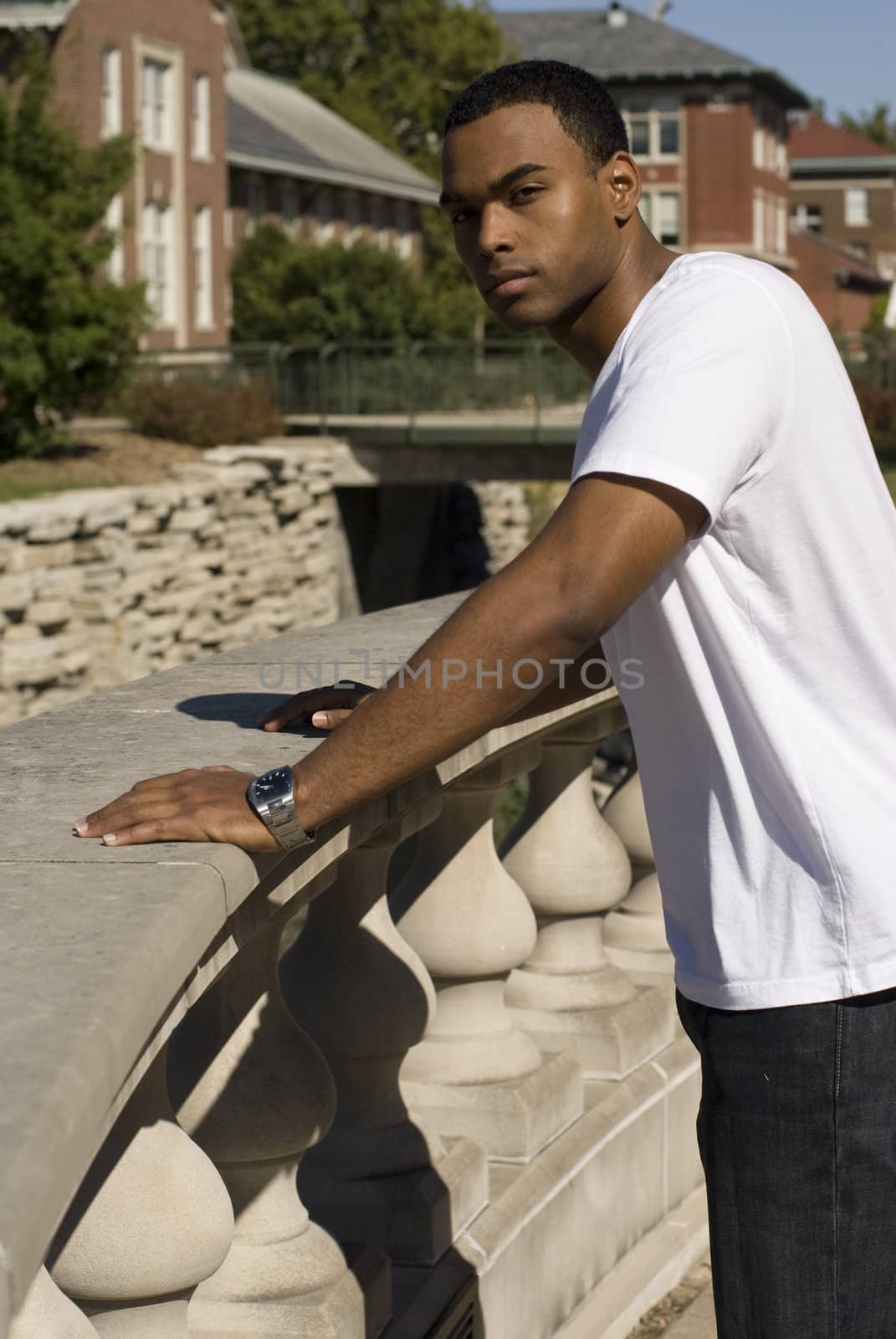 Attractive young African American male playing posing in a white t-shirt and jeans.