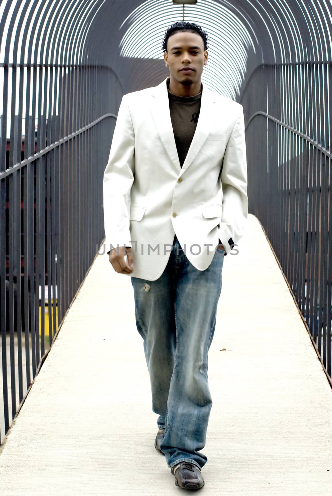 Attractive young man in a suit and jeans on a bridge.