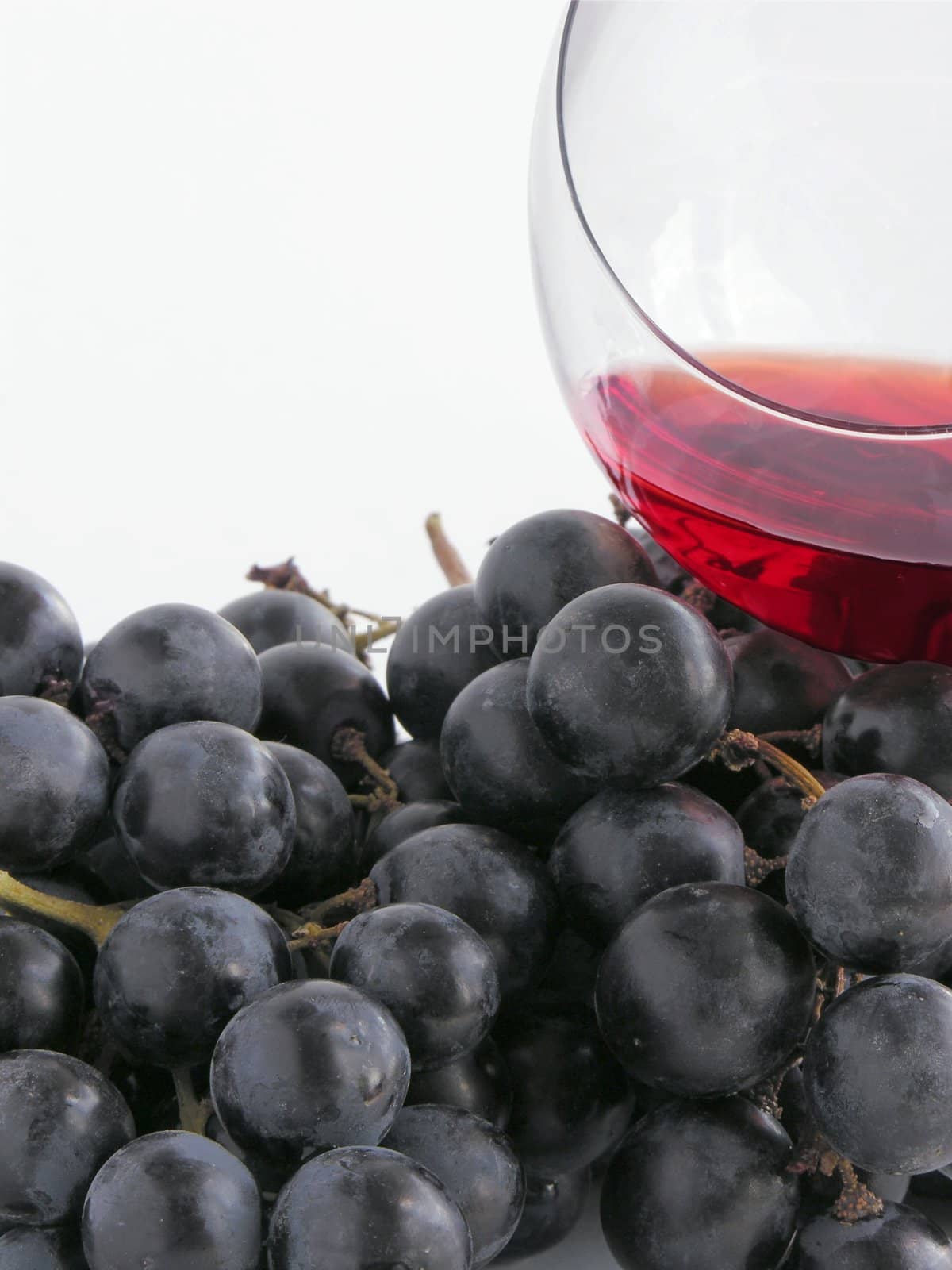 red wine in glass and red grapes by RAIMA