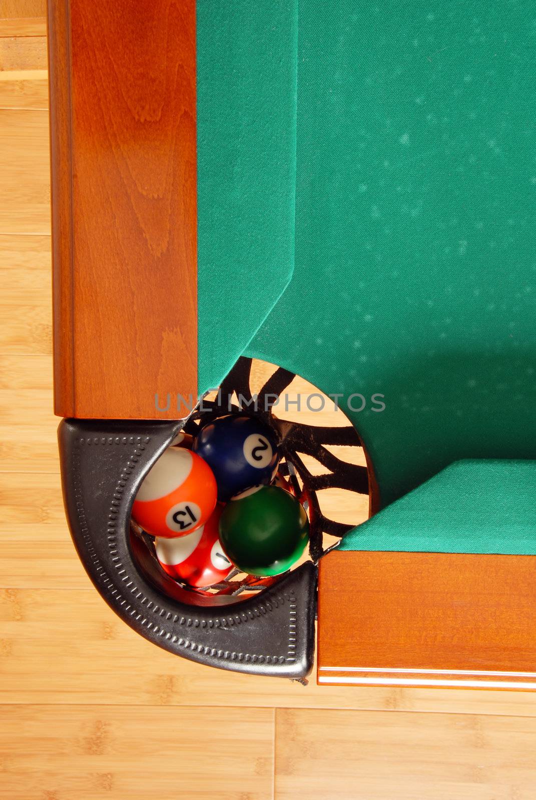 balls in billiards table leather pockets closeup from above