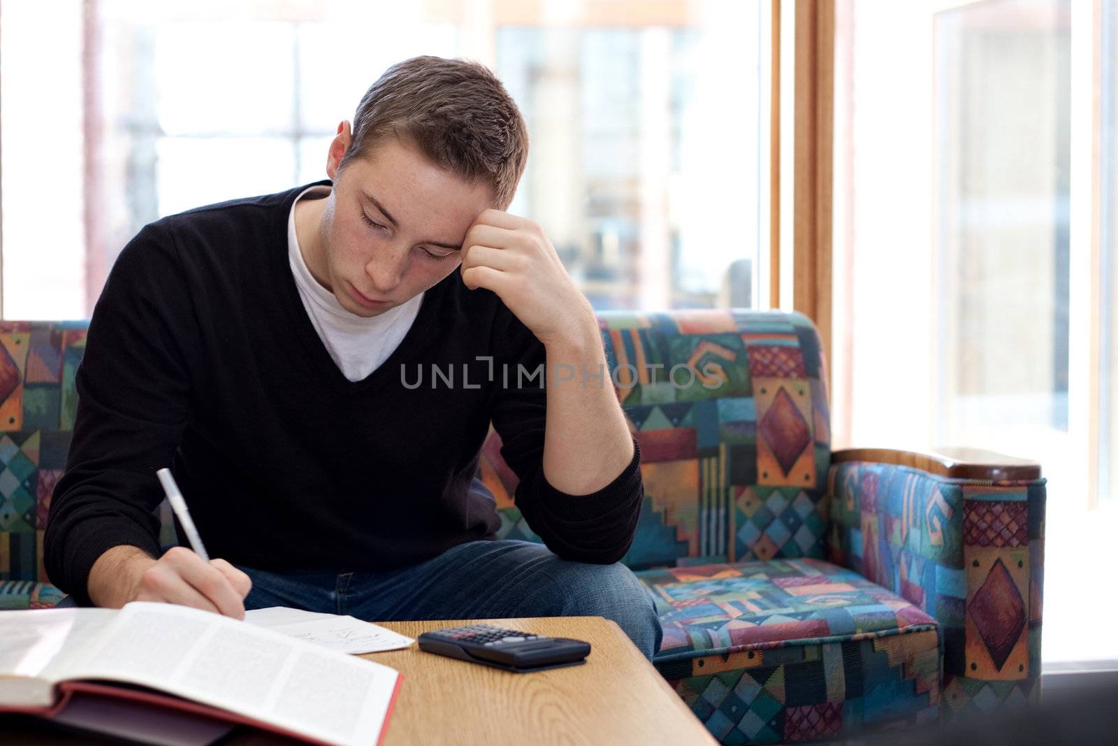 A young college student cramming before his final exams.