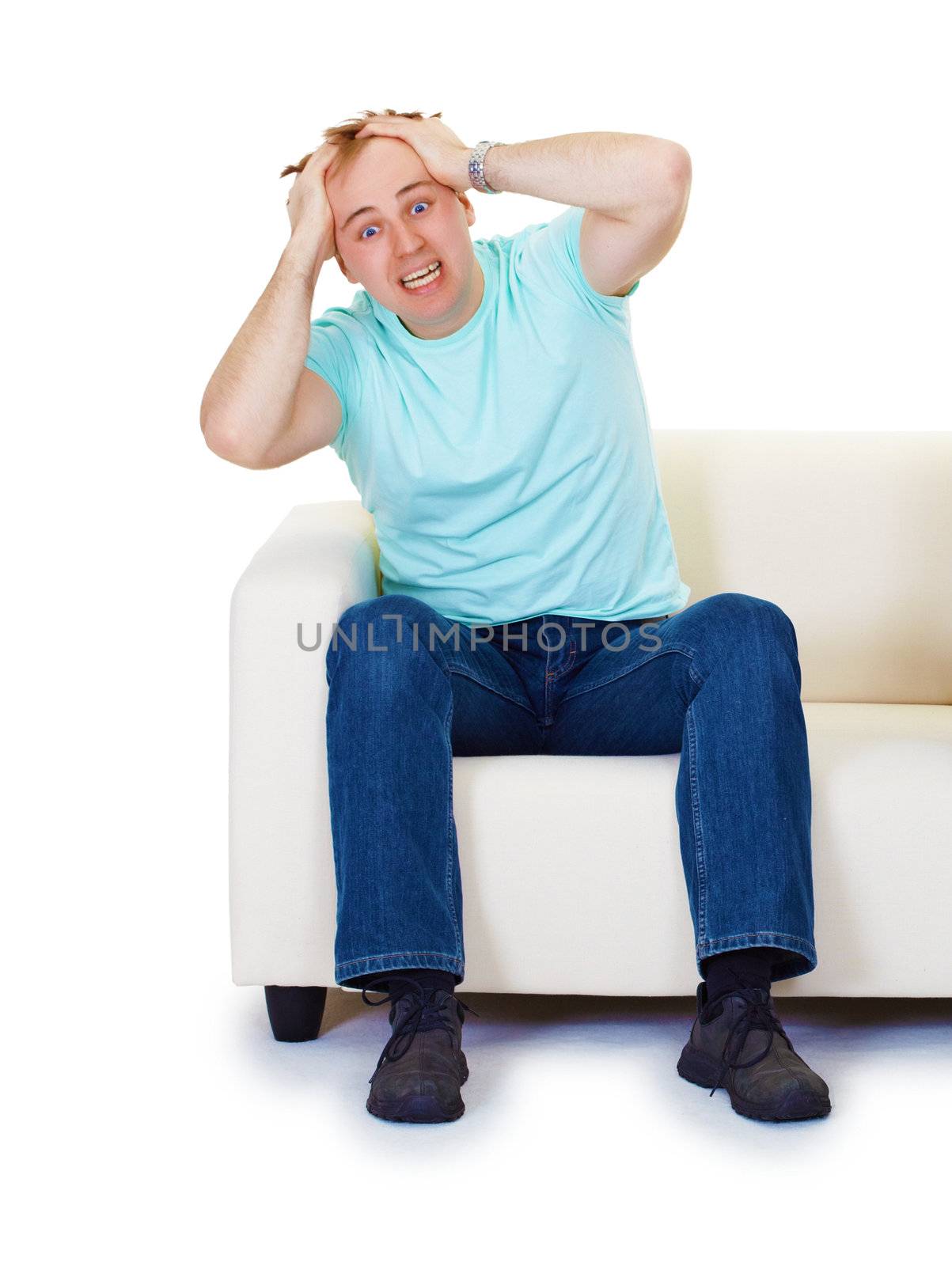 Nervous hysteria man sitting at home on the couch isolated on white background