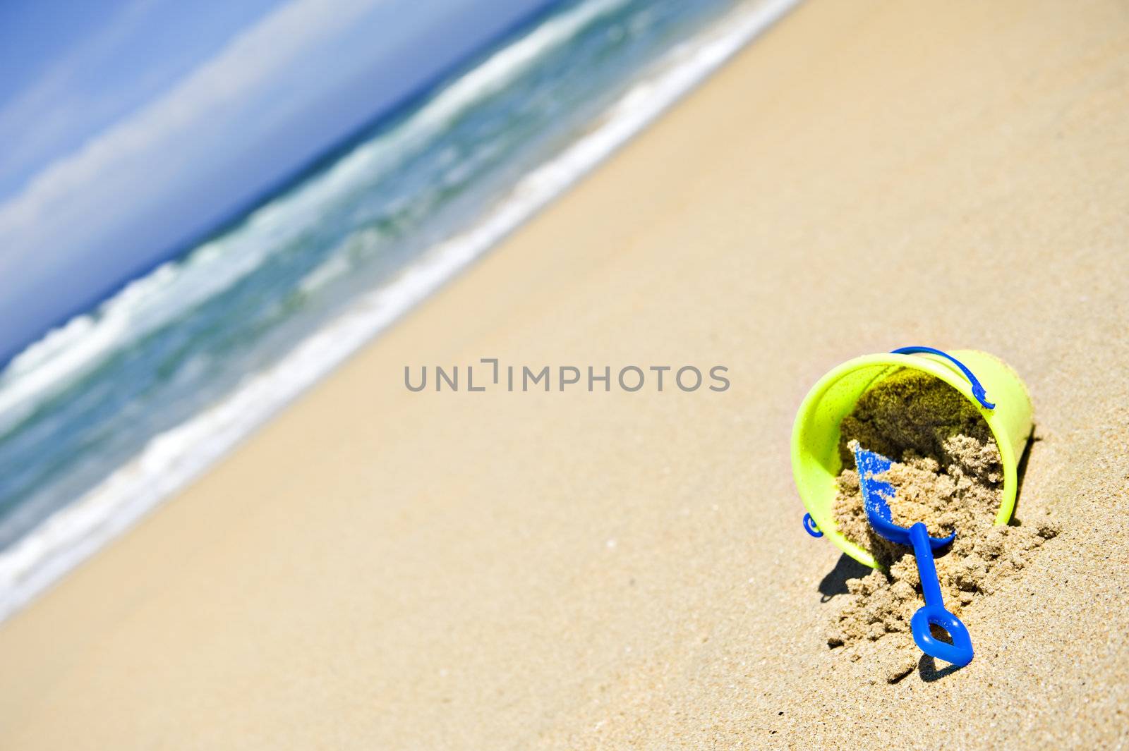 Toy bucket and shovel on an empty beach by tish1