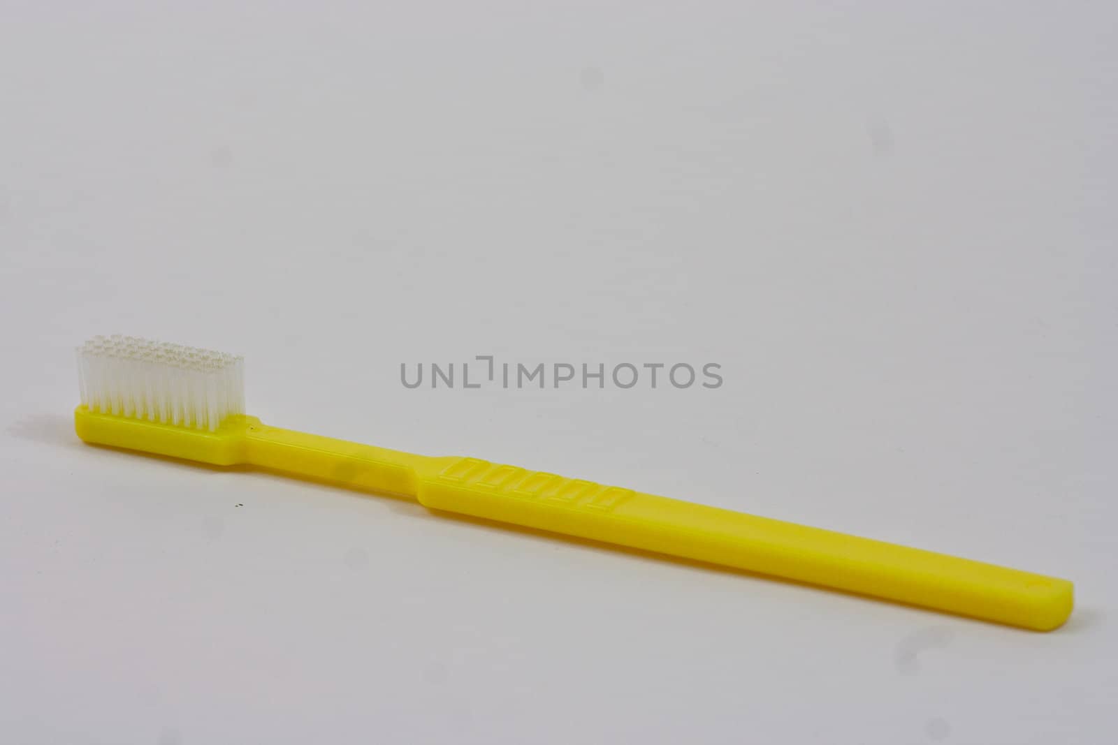 Plain yellow Truthbrush on a white background.