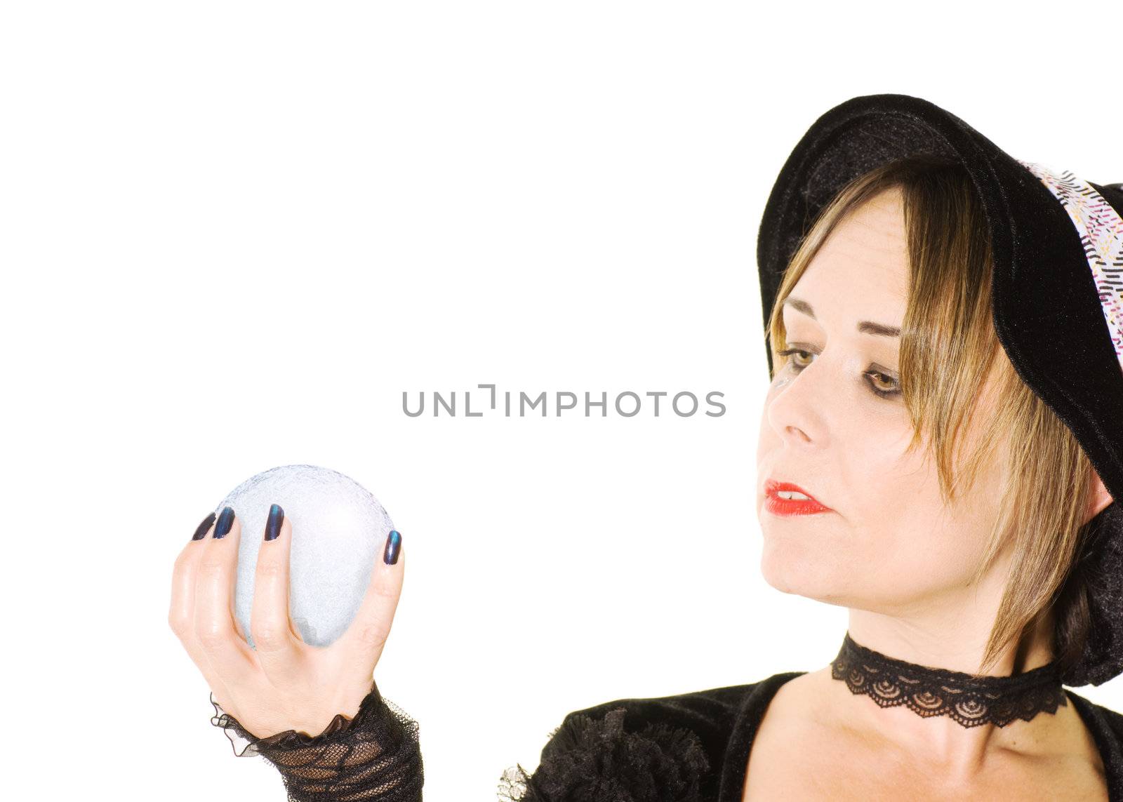 studio photo of a woman dressed as a witch looking at a crystal ball isolated on white