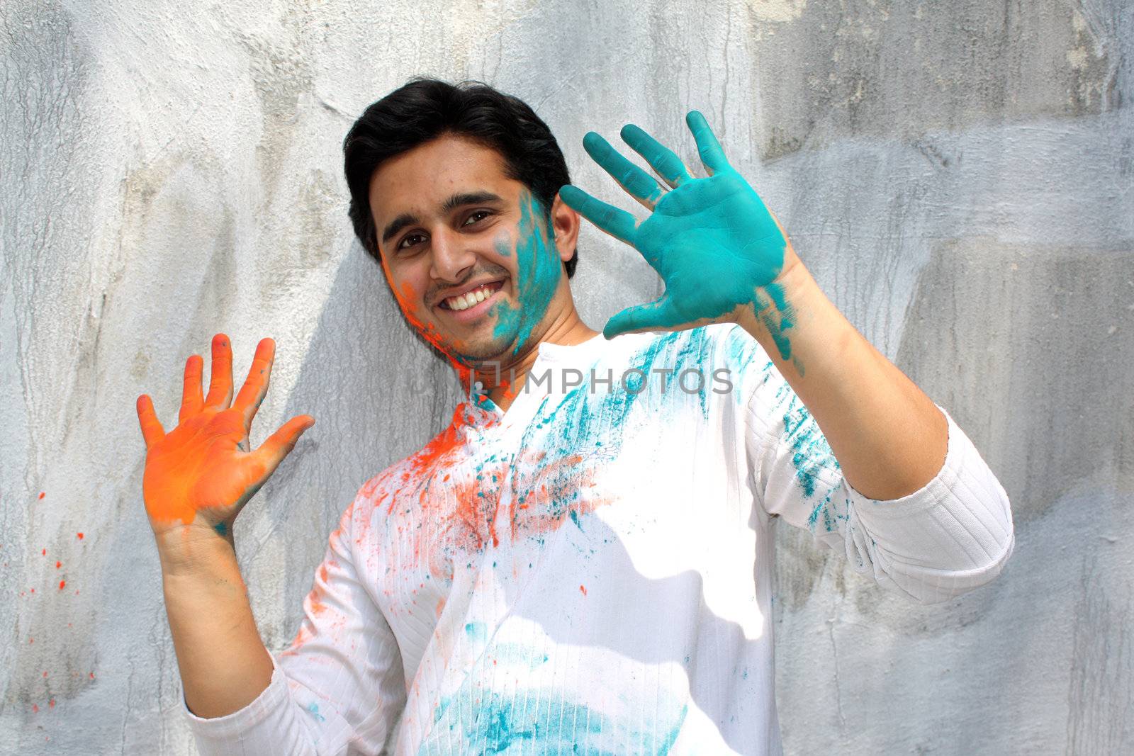 A young Indian guy happy during the festival of colors - Holi.