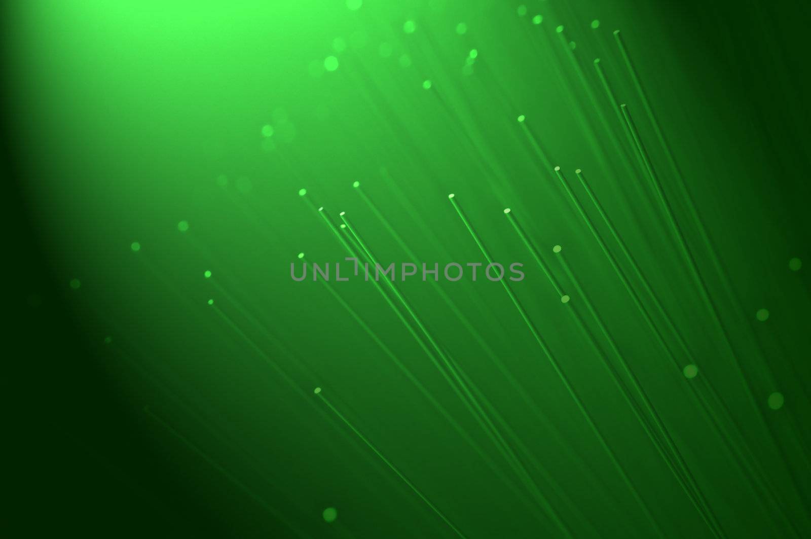 Many ends of green illuminated fiber optic light strands close up with green light effect