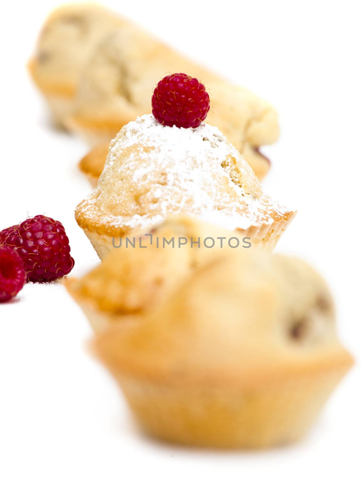 Muffins with raspberries isolated over a white background